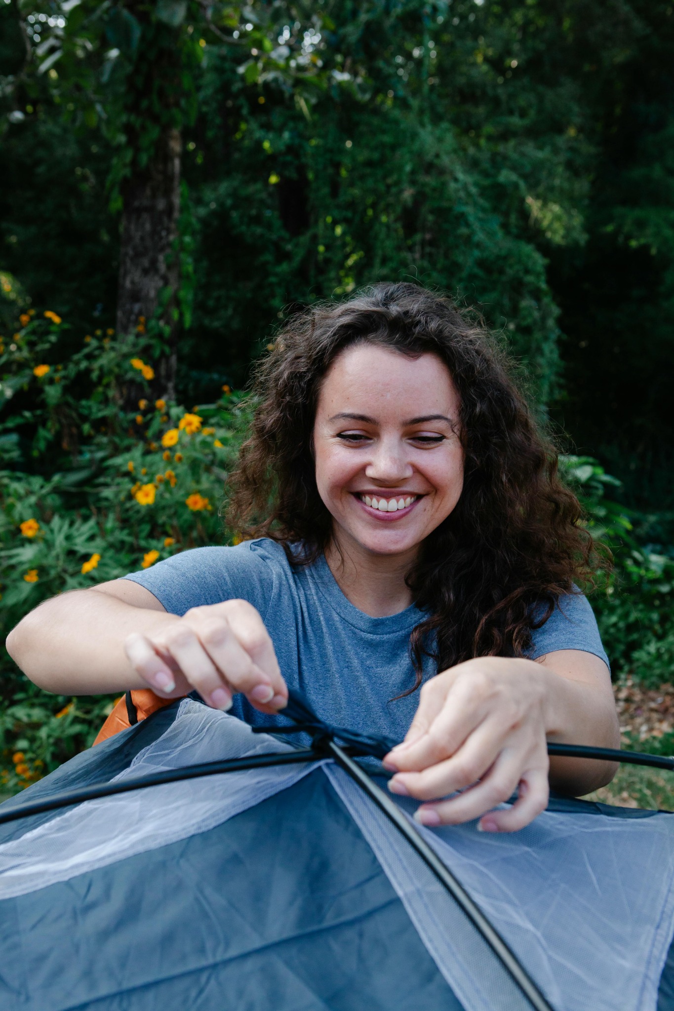 Person setting up a tent outdoors
